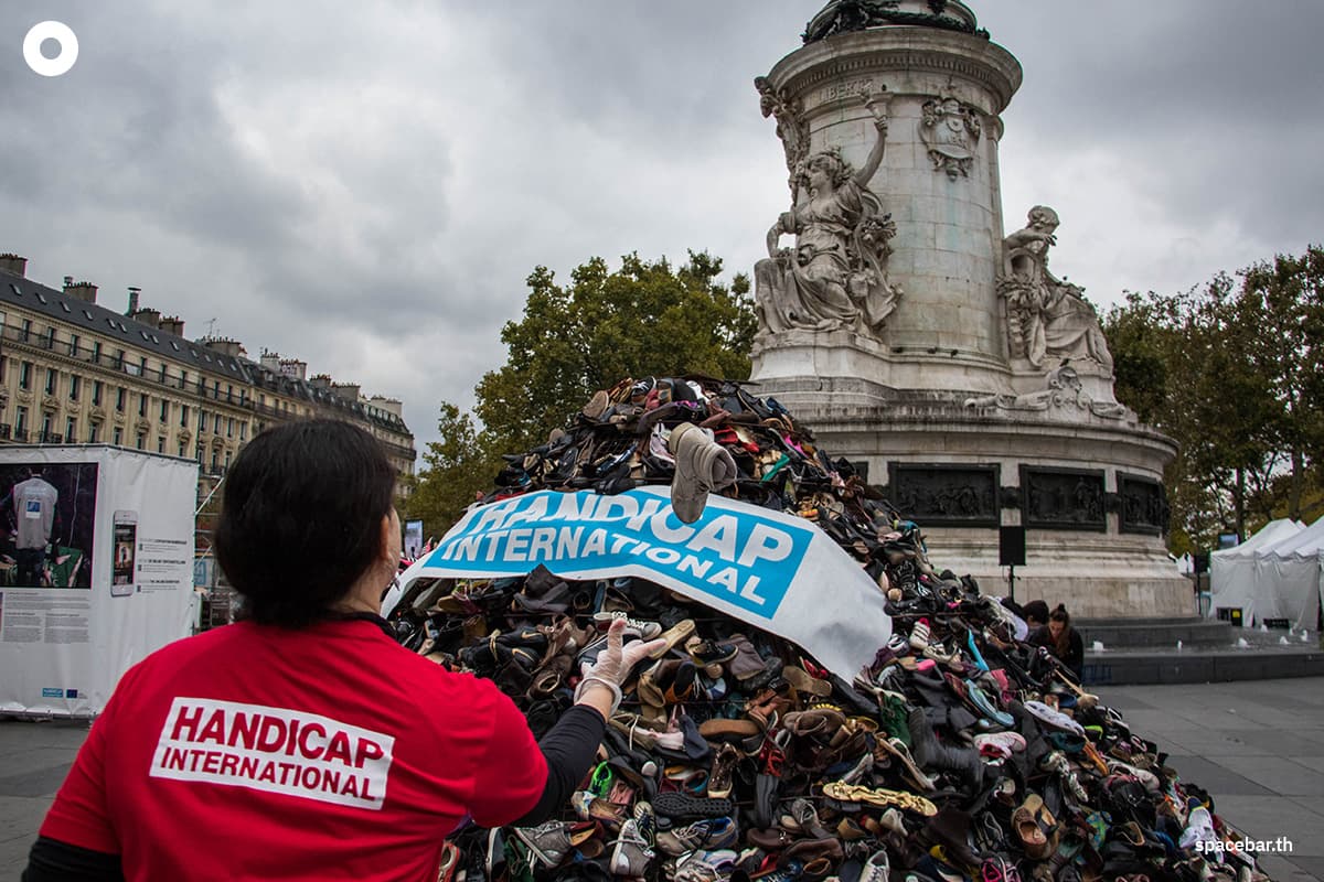    (Photo by AFP / นักเคลื่อนไหวรายหนึ่งโยนรองเท้าเข้าไปบนกองรองเท้าที่ถูกจัดวางโดย ‘Handicap International’ องค์กรพัฒนาเอกชน ณ จัตุรัสปลาสเดอลาเคปูบลิก กรุงปารีส เมื่อวันที่ 22 กันยายน 2017 เนื่องในโอกาสครบรอบ 20 ปีของสนธิสัญญาออตตาวา) 