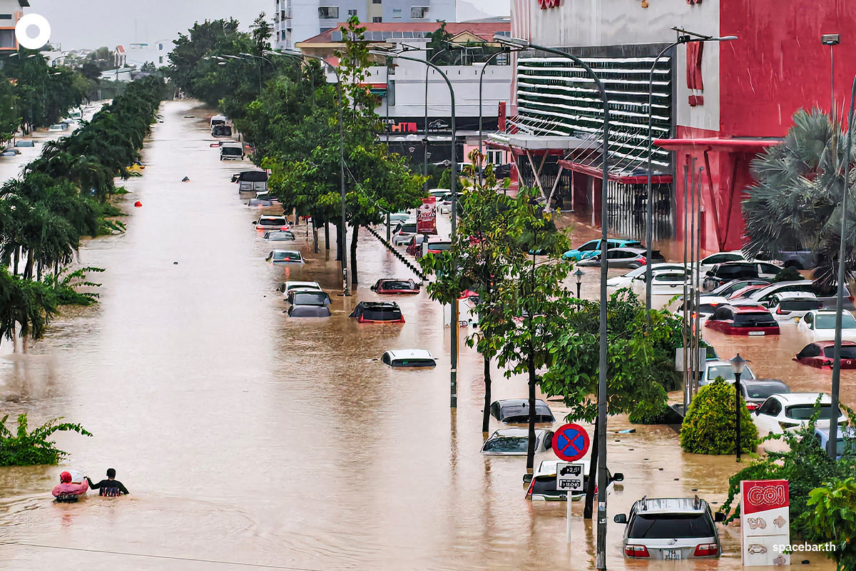 PhotoStory-   ประชาชน 2 คนกำลังเดินลุยน้ำท่วมบนถนนแห่งหนึ่งที่มีรถยนต์ถูกน้ำท่วมเต็มไปหมด ในเมืองญาจาง จังหวัดคั้ญฮหว่า เวียดนาม เมื่อวันที่ 20 พฤศจิกายน 2025 (Photo by DUC THAO / AFP) 