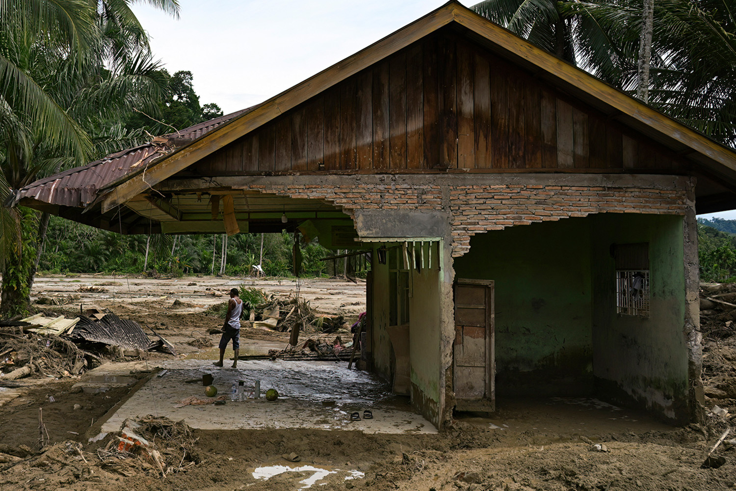PhotoStory- ชาวบ้านคนหนึ่งกำลังยืนมองไปรอบๆ บ้านของเขาที่เสียหายหลังจากเกิดน้ำท่วมฉับพลันในหมู่บ้านเอก กาโรกา จังหวัดสุมาตราเหนือ อินโดนีเซีย เมื่อวันที่ 4 ธันวาคม 2025 (Photo by YT HARIONO / AFP)