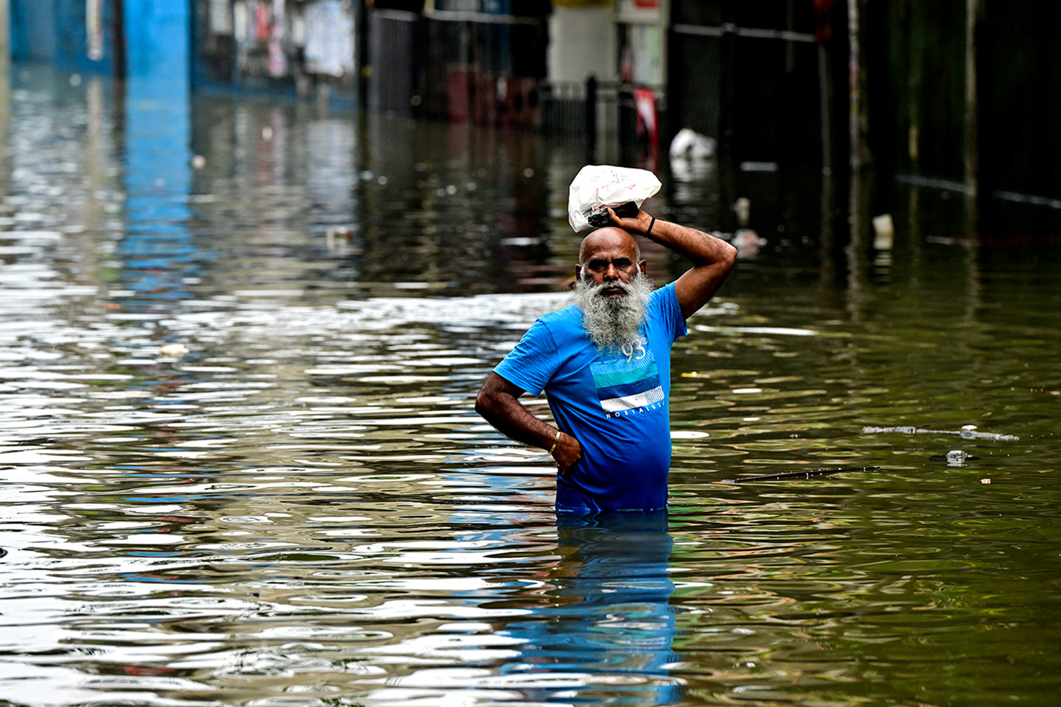 PhotoStory- ชายคนหนึ่งเดินลุยน้ำท่วมถนน หลังฝนตกหนักในเขตเวลลัมปิติยา ชานเมืองโคลัมโบ เมื่อวันที่ 29 พฤศจิกายน 2025 (Photo by ISHARA S. KODIKARA / AFP)