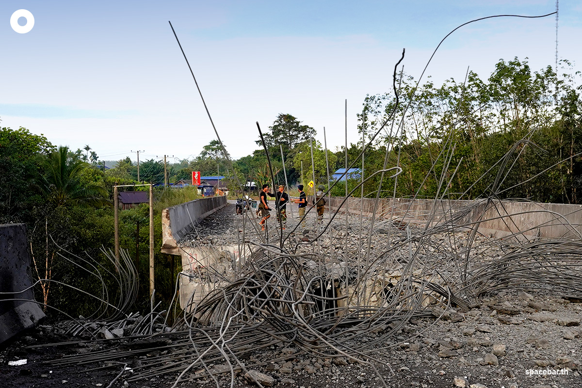 PhotoStory-ชาวกัมพูชายืนดูความเสียหายของสะพานจัยจุมเนี๊ยะหลังกองทัพอากาศส่ง F-16 ทิ้งไข่ถล่มเพื่อตัดเส้นทางลำเลียงอาวุธของกัมพูชาPhoto by STR / AFP