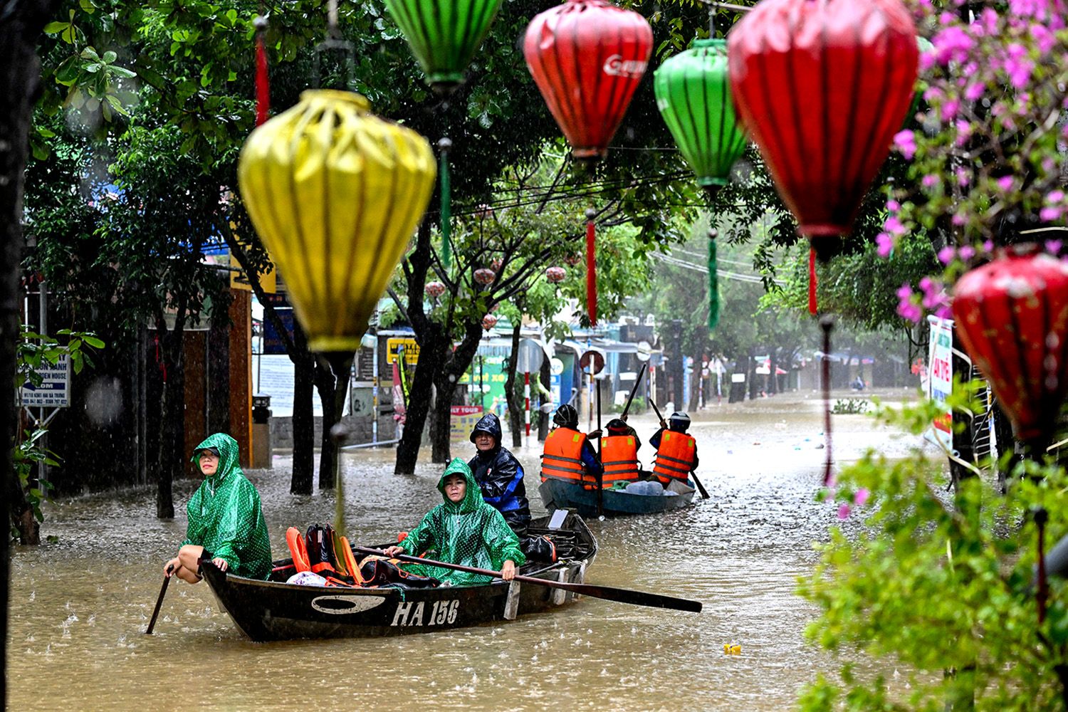 PhotoStory- ชาวบ้านล่องเรือไปตามถนนที่ถูกน้ำท่วมท่ามกลางฝนตกหนักในเมืองฮอยอัน เมื่อวันที่ 30 ตุลาคม 2025 (Photo by NHAC NGUYEN / AFP)